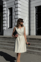 a lady in a white vest dress with a belt